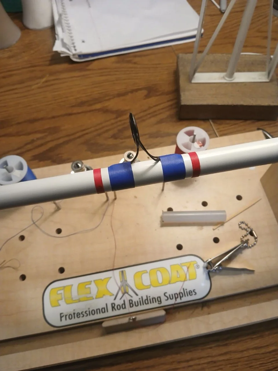 Red, white, and blue thread wraps securing a guide on a BDRX Customs rod in progress.